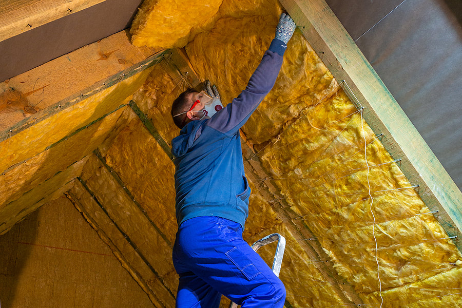 The man insulates the house's attic with mineral wool in Fairfield, CT.